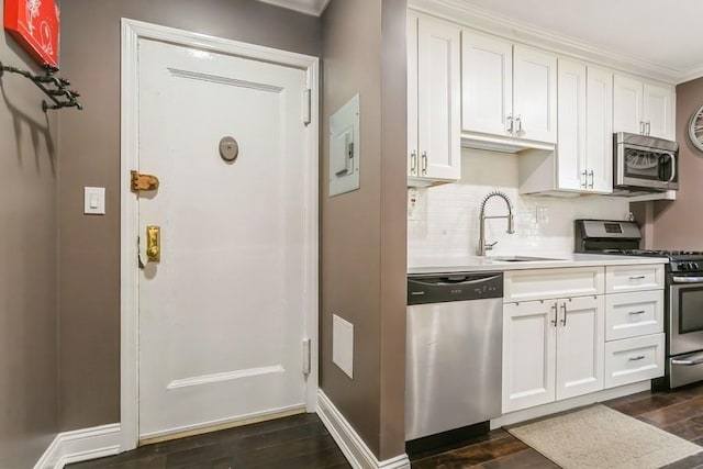 kitchen with appliances with stainless steel finishes, dark wood-style flooring, white cabinetry, and tasteful backsplash