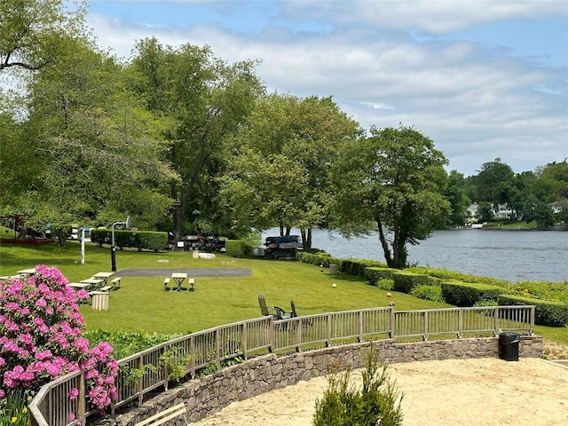 view of property's community featuring a lawn and a water view