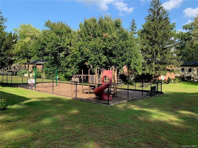 communal playground featuring a lawn and fence