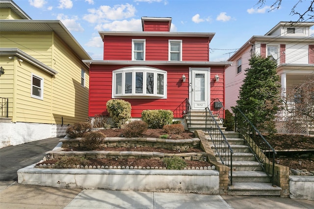 traditional style home with entry steps and driveway