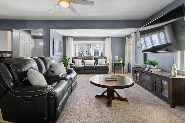 living room featuring a ceiling fan and light colored carpet