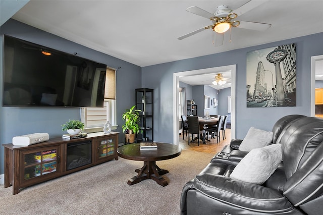 living area with a ceiling fan and carpet flooring