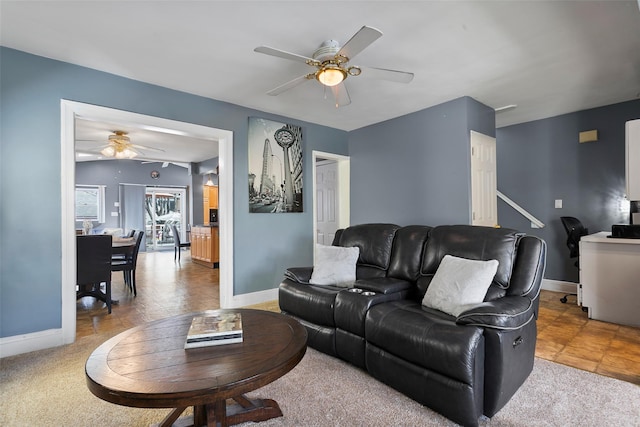 living room with ceiling fan and baseboards