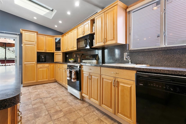 kitchen with decorative backsplash, dark countertops, lofted ceiling with skylight, black appliances, and a sink