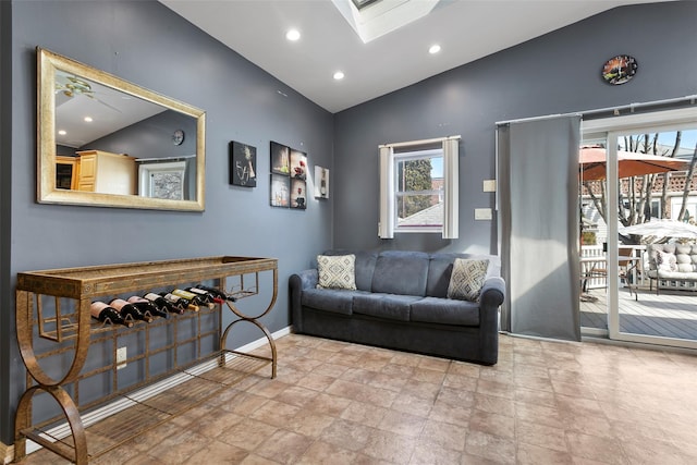 sitting room with lofted ceiling with skylight, baseboards, and recessed lighting