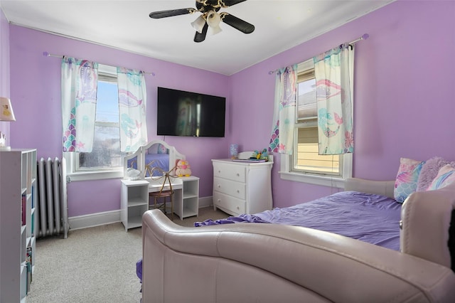 carpeted bedroom with a ceiling fan, radiator, and baseboards