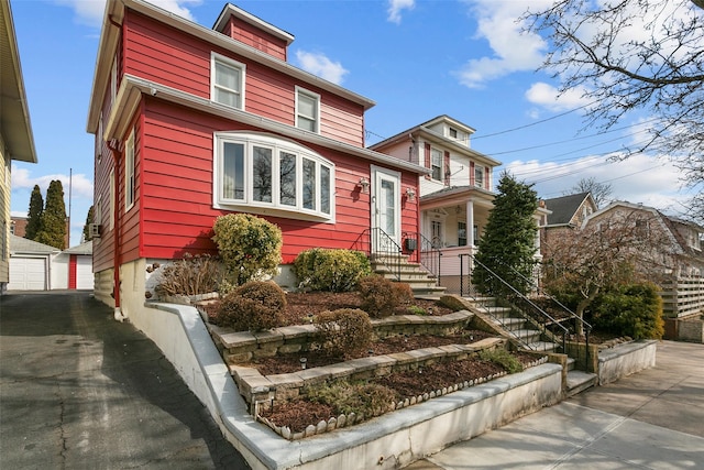 american foursquare style home featuring a garage and an outdoor structure