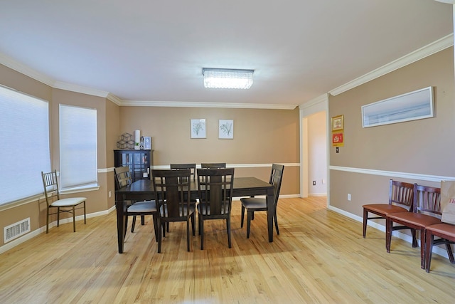 dining space featuring ornamental molding, baseboards, visible vents, and light wood finished floors