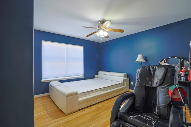 bedroom featuring baseboards, a ceiling fan, and wood finished floors