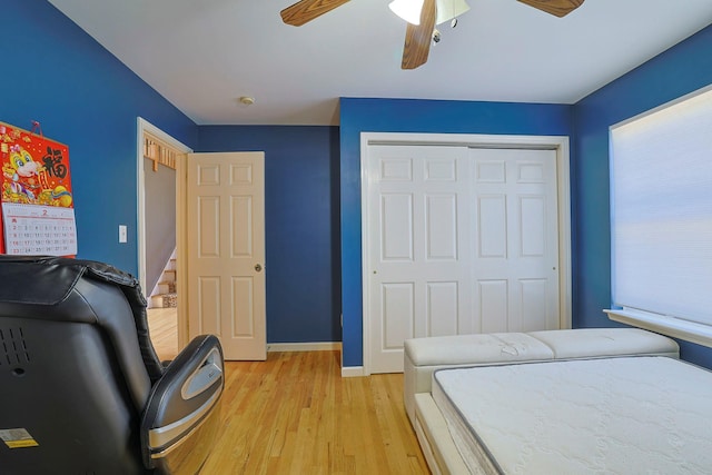 bedroom featuring light wood-type flooring, a closet, ceiling fan, and baseboards