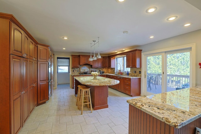 kitchen featuring a sink, a breakfast bar, a kitchen island, and tasteful backsplash