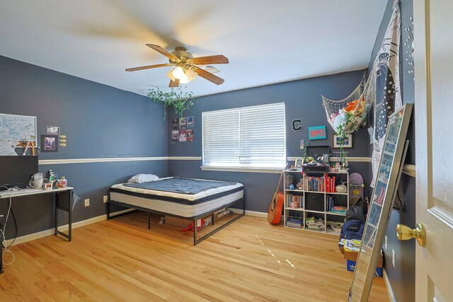 bedroom with a ceiling fan, baseboards, and wood finished floors