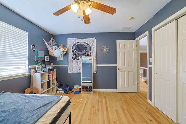 bedroom featuring visible vents, ceiling fan, baseboards, and wood finished floors