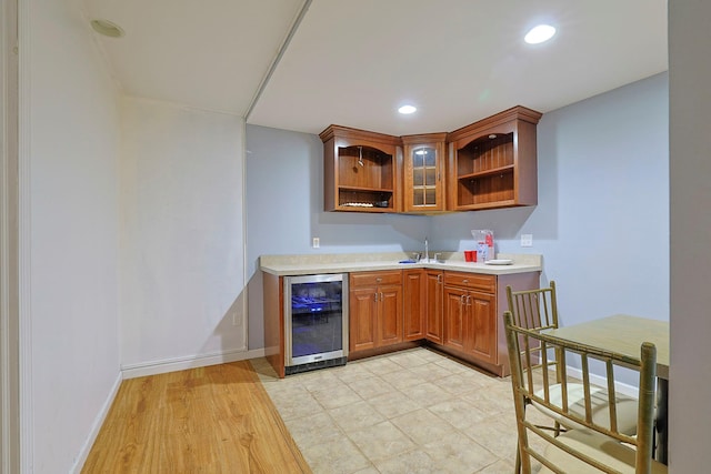 bar featuring beverage cooler, baseboards, wet bar, a sink, and recessed lighting