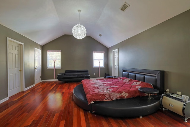 bedroom featuring a chandelier, wood finished floors, visible vents, baseboards, and vaulted ceiling