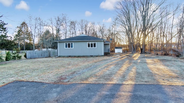 exterior space with crawl space, roof with shingles, and fence