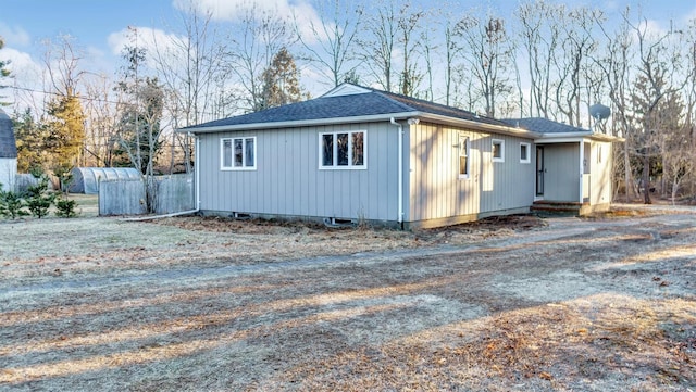 exterior space with driveway and a shingled roof