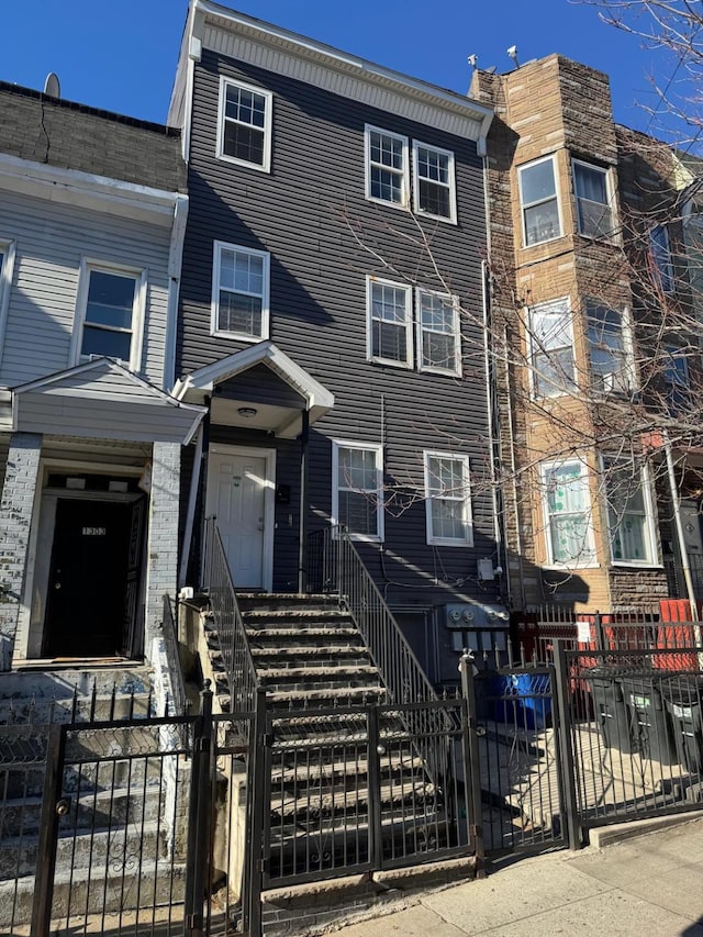 multi unit property featuring a fenced front yard and a gate