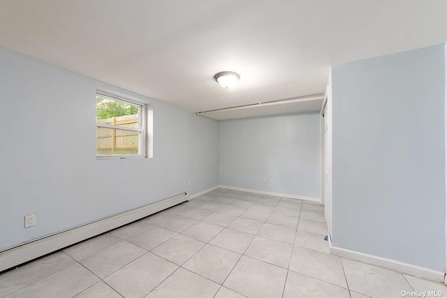 spare room featuring baseboards, baseboard heating, and light tile patterned flooring