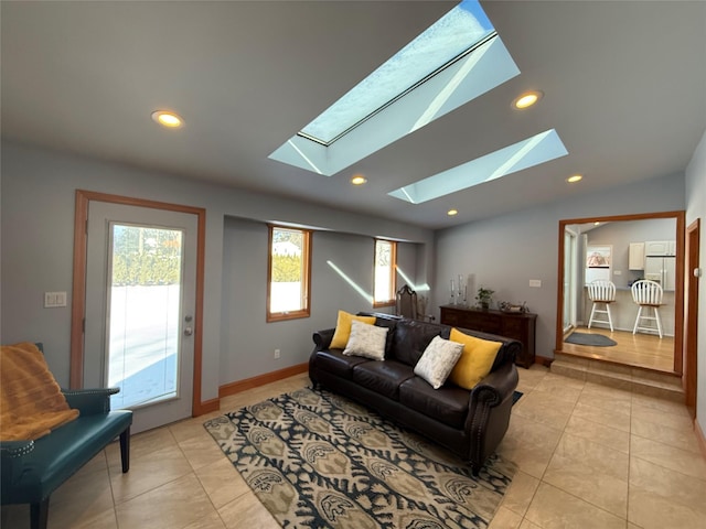 living area with lofted ceiling with skylight, recessed lighting, light tile patterned flooring, and baseboards