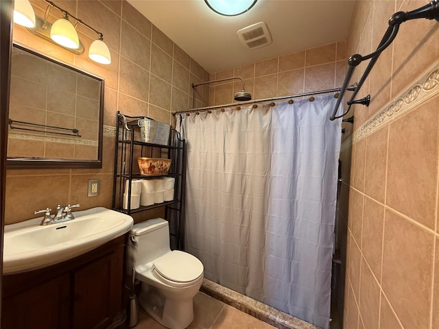 full bathroom with tile patterned flooring, toilet, vanity, tile walls, and a tile shower