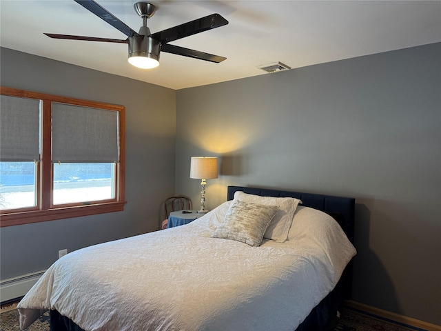 bedroom featuring a ceiling fan, visible vents, and a baseboard heating unit