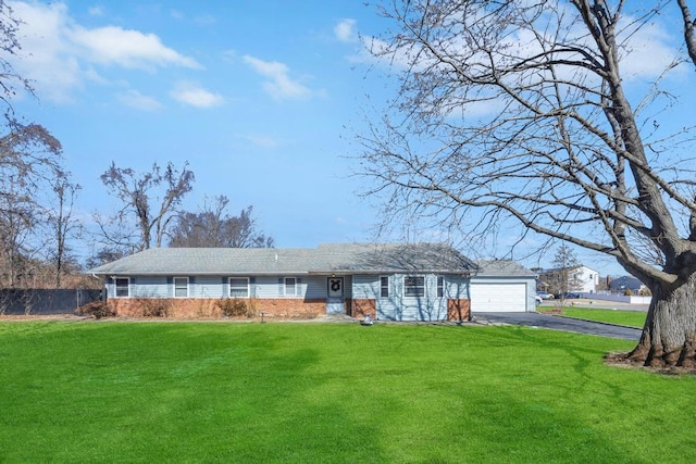 ranch-style house featuring driveway, a garage, fence, and a front yard