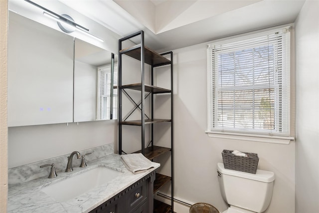 bathroom with baseboard heating, vanity, and toilet