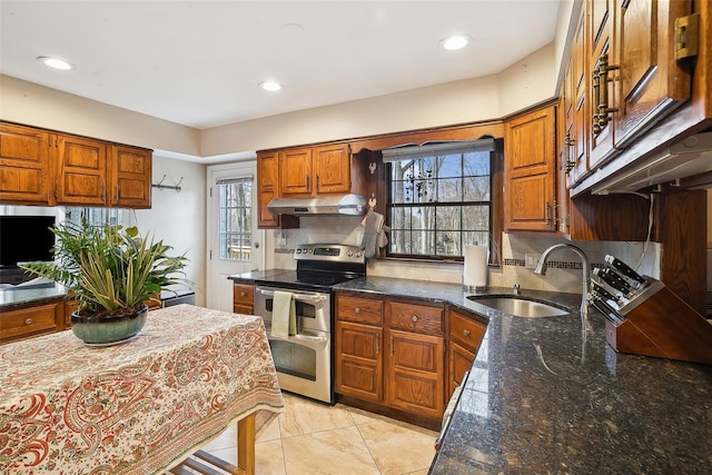 kitchen with tasteful backsplash, brown cabinetry, a sink, double oven range, and under cabinet range hood