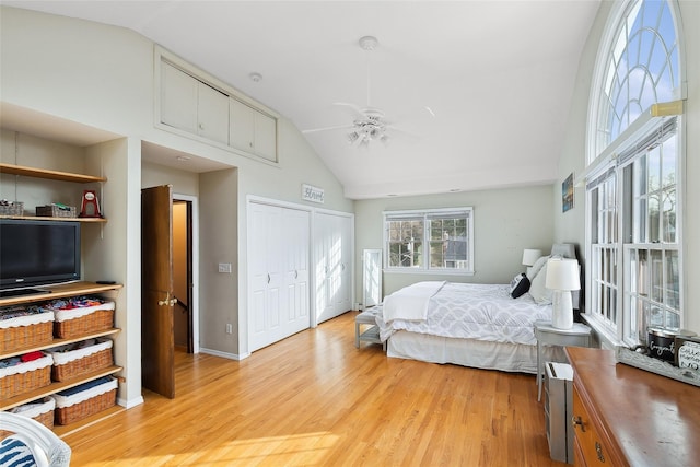 bedroom featuring light wood-style floors, baseboards, high vaulted ceiling, and a ceiling fan