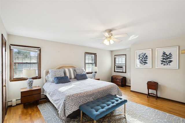 bedroom with baseboards, a ceiling fan, a baseboard radiator, cooling unit, and light wood-type flooring