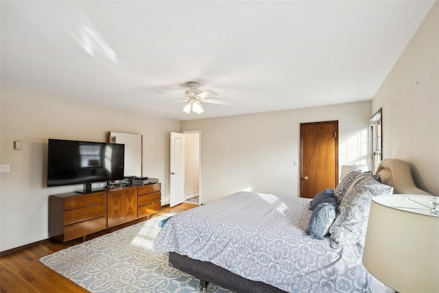 bedroom featuring a ceiling fan, baseboards, and wood finished floors