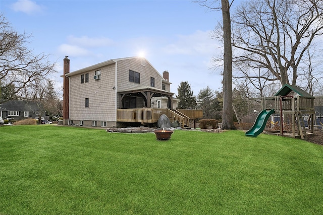 view of property exterior featuring an outdoor fire pit, a playground, a yard, and a chimney