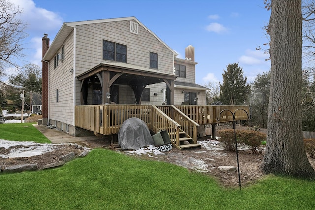 view of front of house featuring a deck, a chimney, and a front lawn