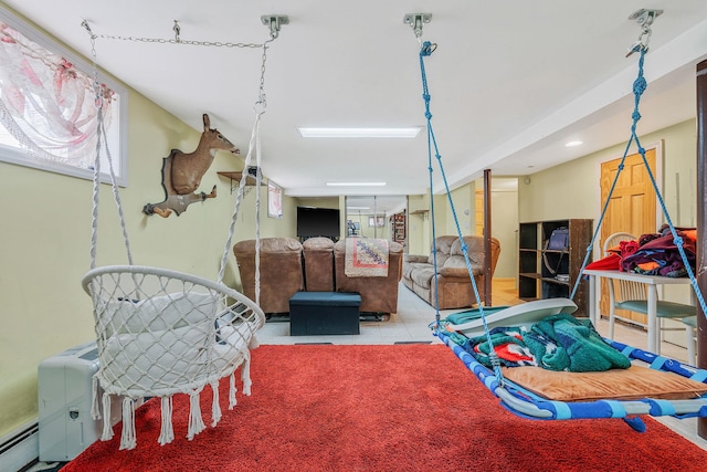 playroom featuring a baseboard heating unit and light tile patterned flooring