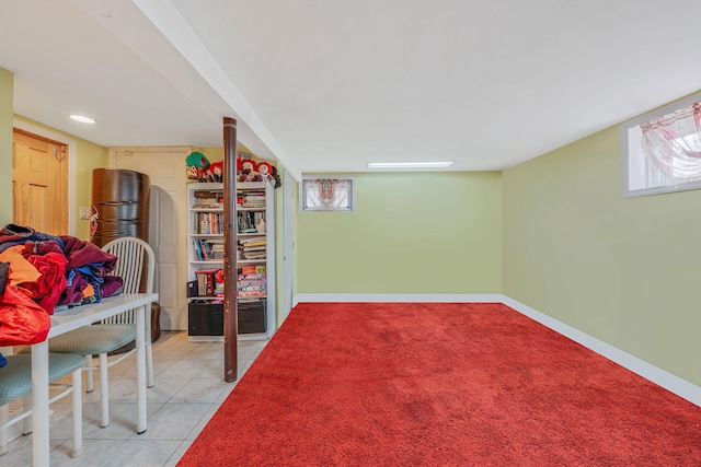 interior space featuring light tile patterned floors, light colored carpet, a wealth of natural light, and baseboards