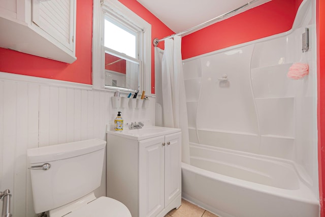 full bathroom featuring shower / bath combination with curtain, toilet, wainscoting, vanity, and tile patterned floors