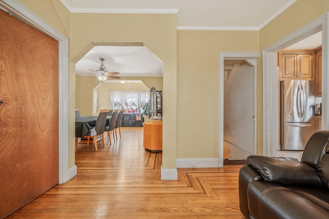 interior space with parquet floors, baseboards, ornamental molding, and arched walkways