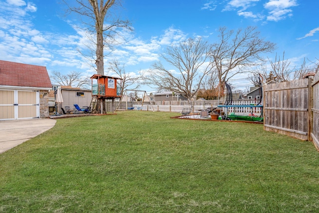 view of yard featuring an outbuilding, fence private yard, a trampoline, a shed, and a playground