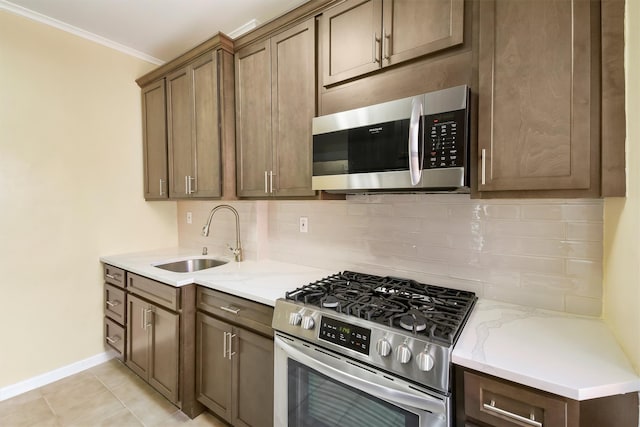 kitchen with stainless steel appliances, tasteful backsplash, a sink, and light stone countertops