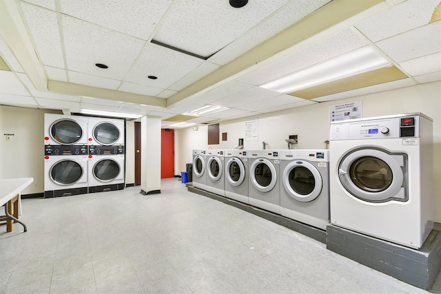 common laundry area with stacked washing maching and dryer, baseboards, washer and clothes dryer, and light floors