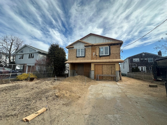 view of front of home featuring driveway and fence