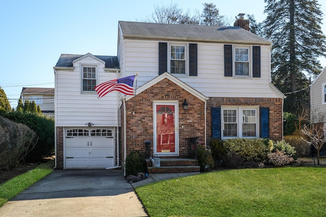 view of front of house with a front yard, driveway, a chimney, and brick siding