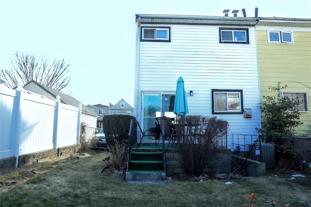 back of property featuring central AC and fence