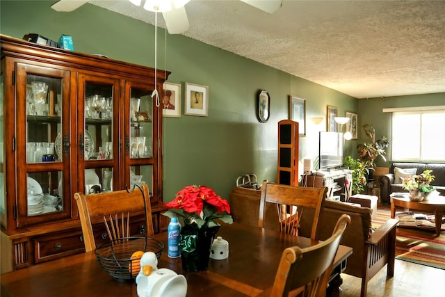 dining area featuring a textured ceiling and wood finished floors