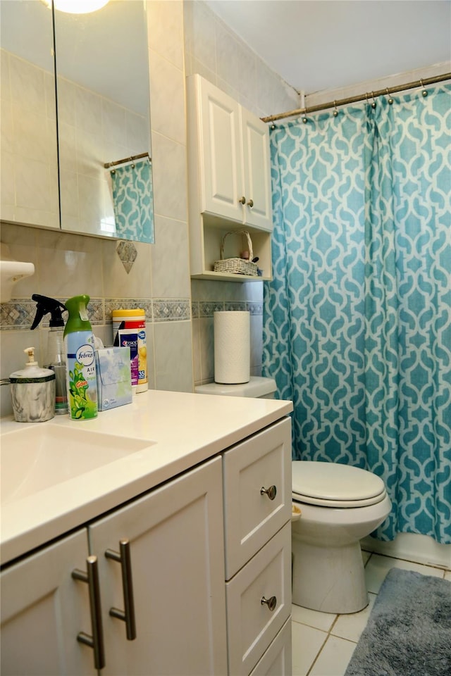 bathroom with tile patterned flooring, toilet, vanity, and tile walls