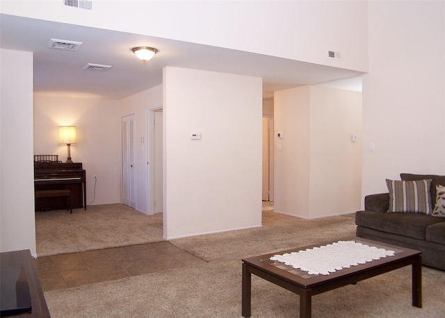 tiled living room with carpet and visible vents