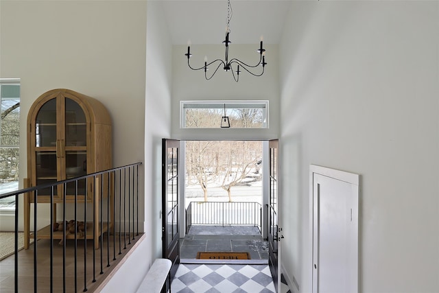 entryway featuring a chandelier and a towering ceiling