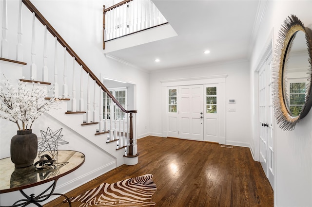 foyer with crown molding, stairs, and dark wood-style flooring