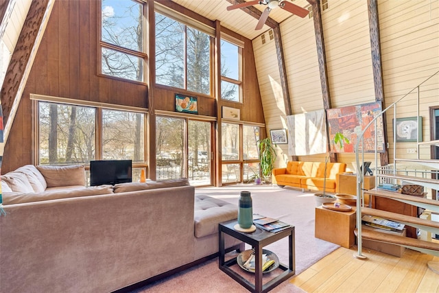 living room featuring plenty of natural light, wood ceiling, and wooden walls